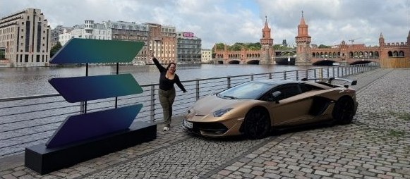 Ari posing next to the Solana logo by the river in Berlin